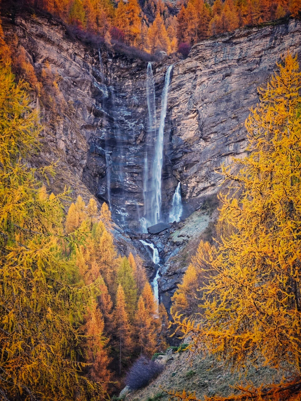 La cascade de la Pisse a Champoléon, tra i larici d'autunno