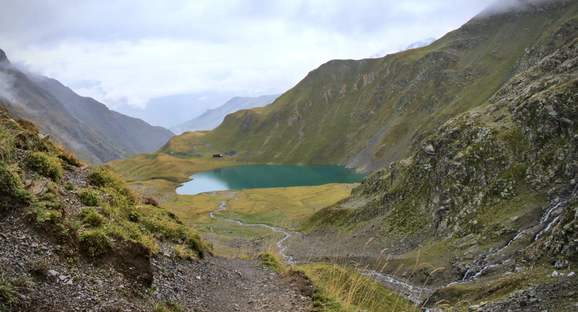 Il Lac de la Muzelle visto dal sentiero di discesa, con il rifugio in riva all'acqua